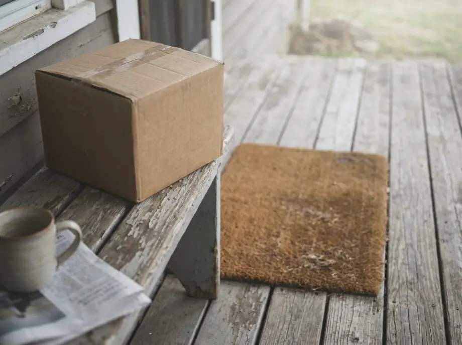 A plain unbranded parcel resting on a porch bench